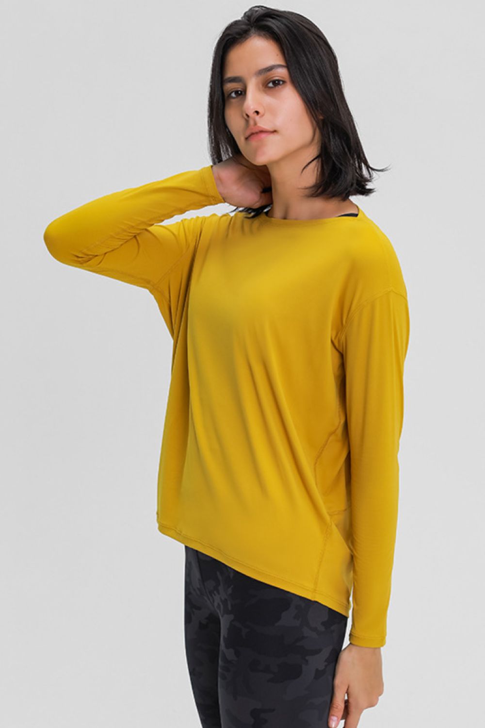 Loose-fit active top in mustard yellow, long sleeves and crew neckline.