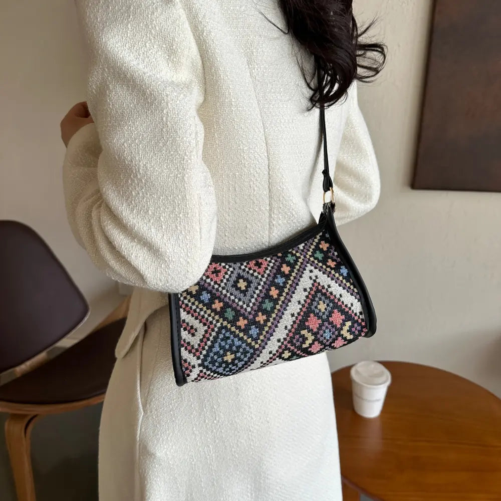Geometric crossbody bag with colorful print, worn on shoulder with crossbody strap