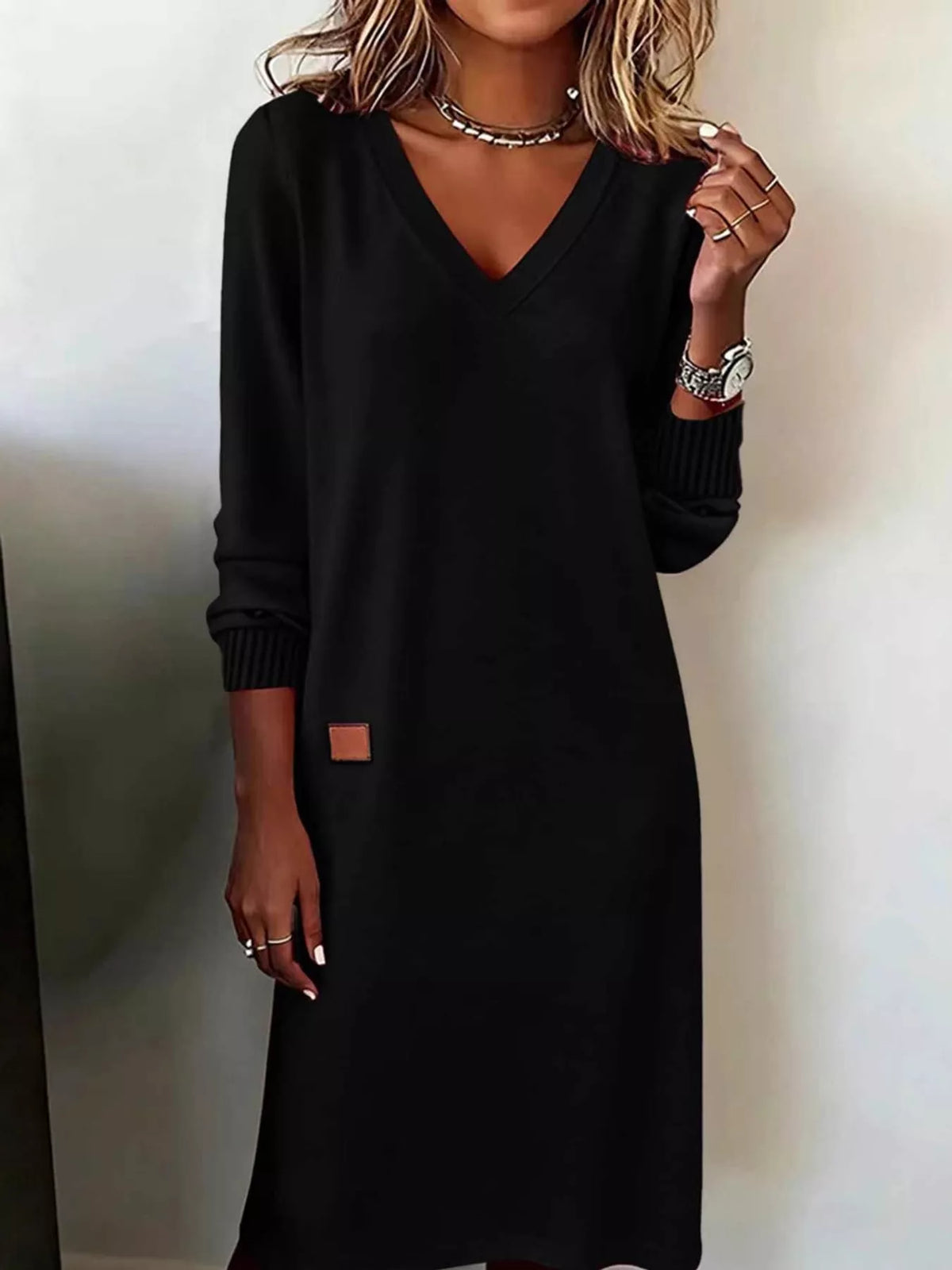 V-neck long-sleeve midi dress in black, front view with cuffed sleeves and small patch