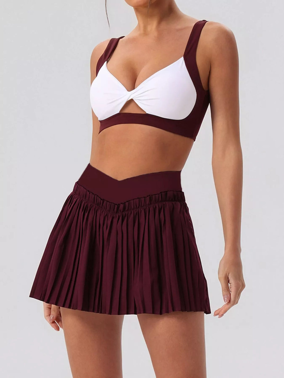 Two-piece set: sleeveless twist bra top and pleated mini skirt, burgundy/white