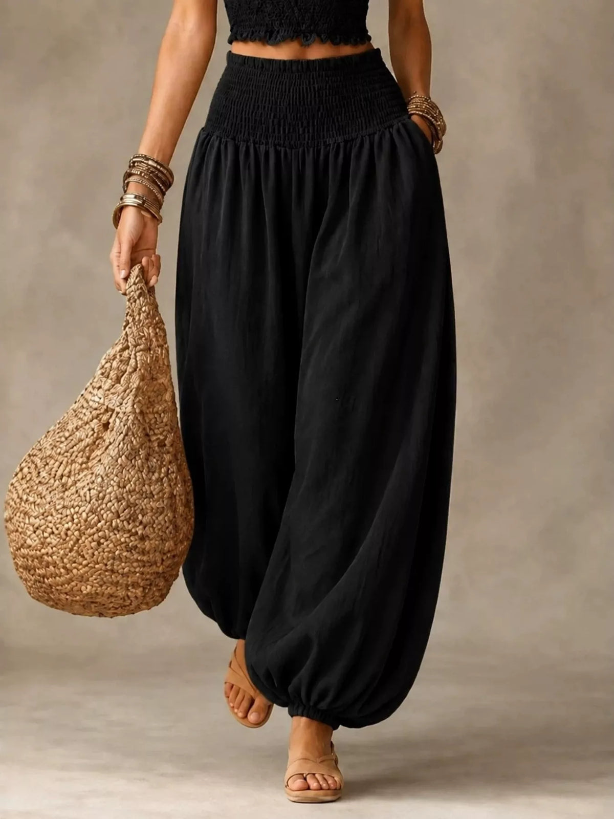 Black elastic-waist smocked harem pants, flowing wide legs with cuff gathers
