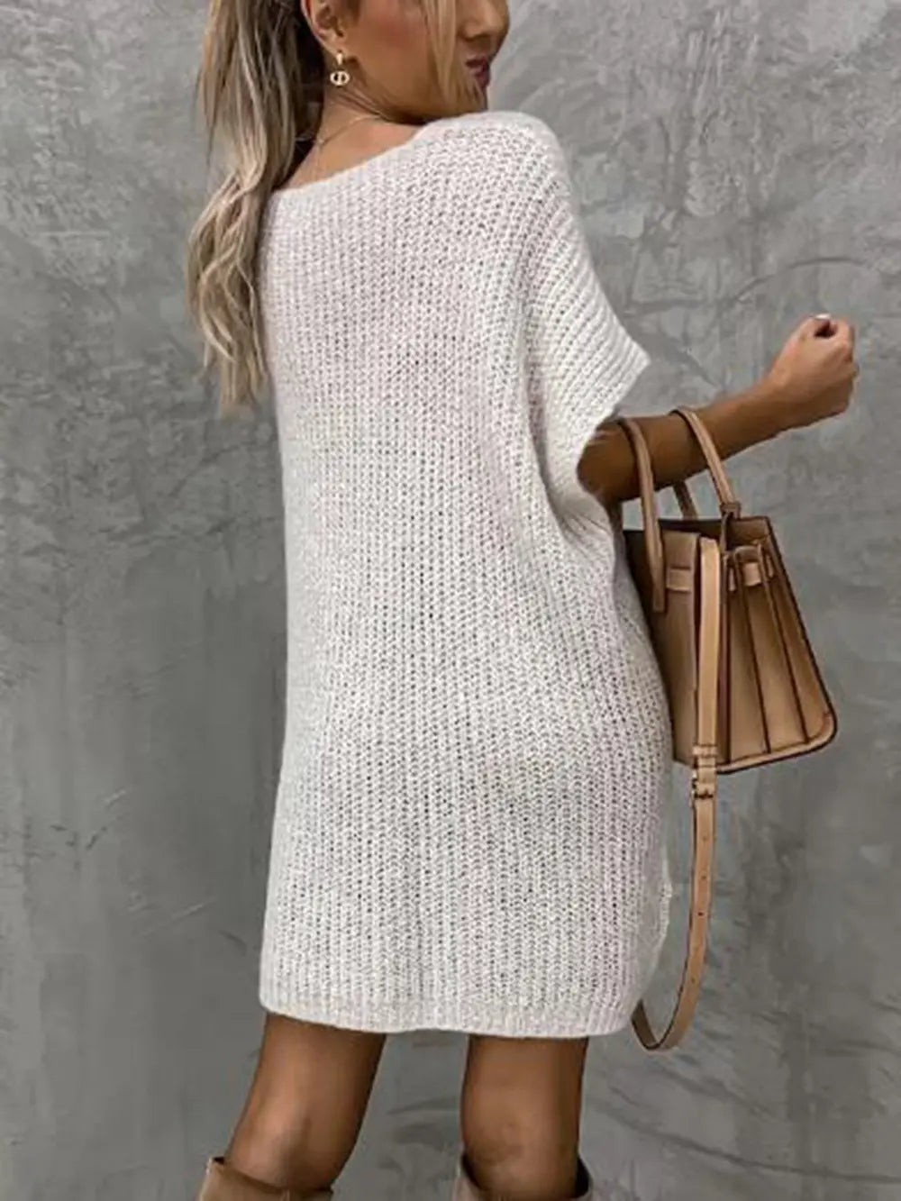 White short-sleeve knit sweater from the back, tunic-length silhouette.