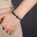 Blue beaded bracelet with teardrop dark blue stone and gold-tone setting