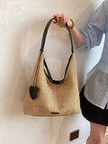 Camel woven straw shoulder bag with black top trim and small front pocket
