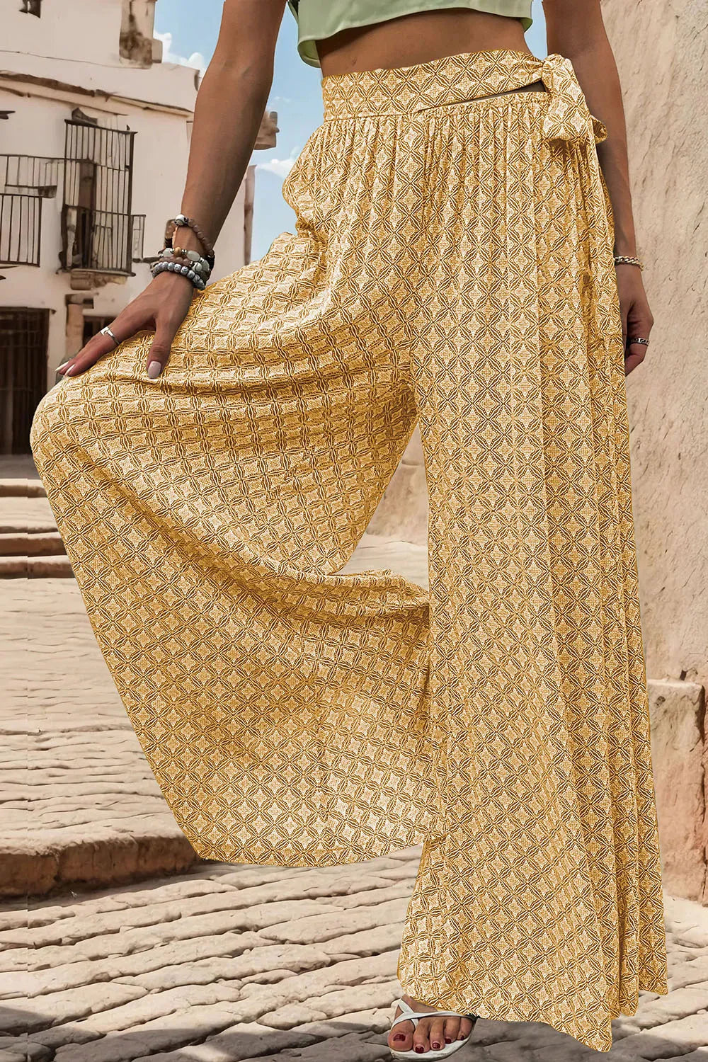Yellow printed wide-leg pants with tied waist detail and billowy wide pant legs
