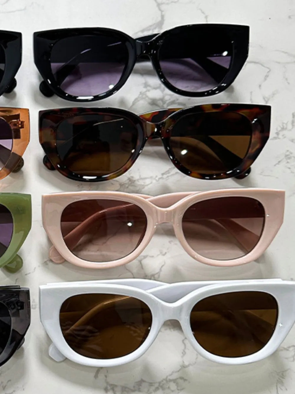 Assorted cat-eye polycarbonate sunglasses in black, tortoiseshell, pink, and white frames