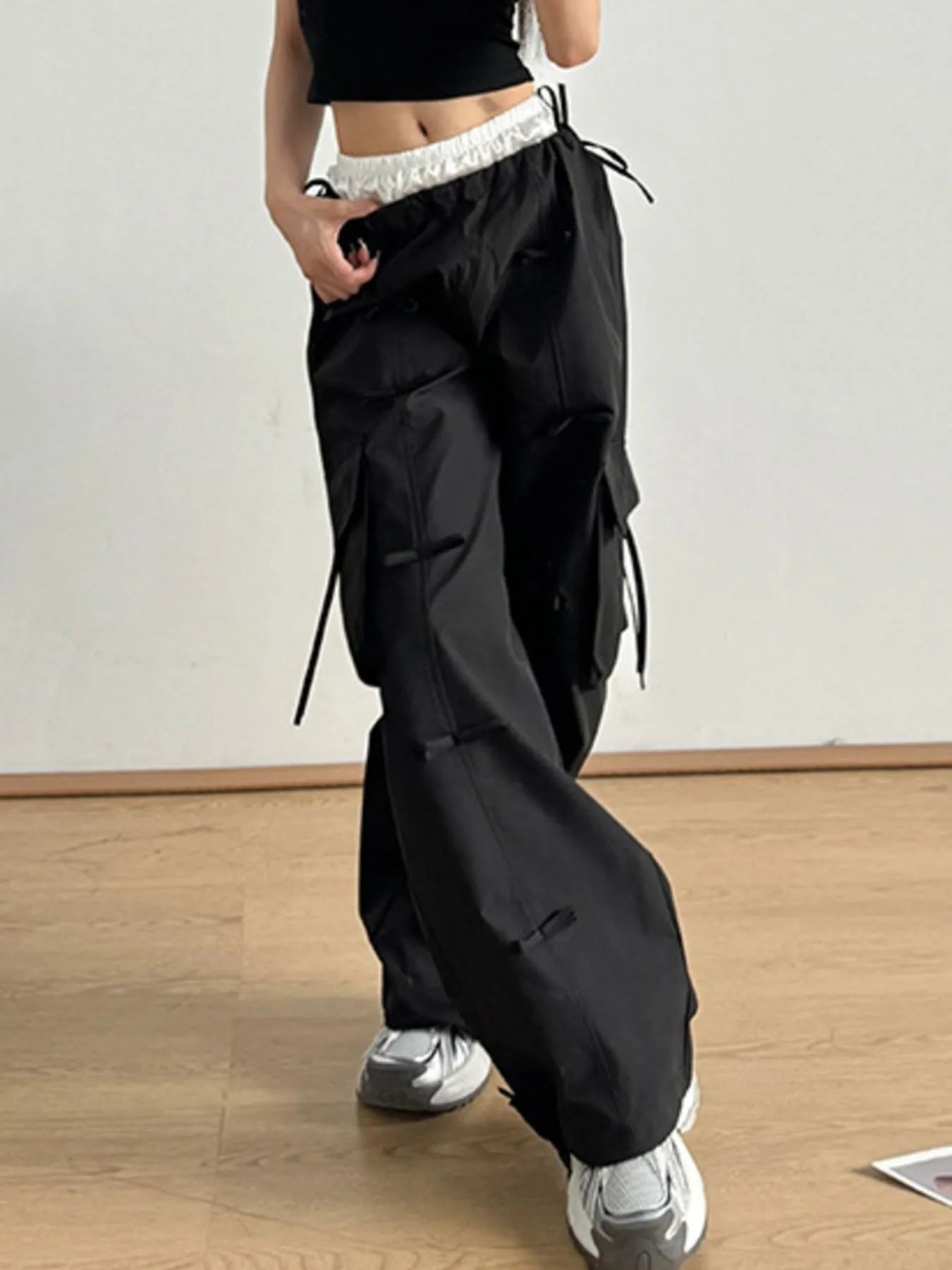 Black elastic-waist cargo pants with side pockets and drawcord tie details