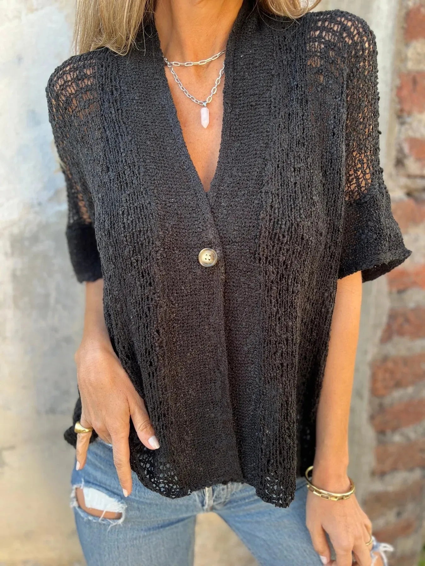 Openwork V-neck one-button cardigan with short sleeves and relaxed fit in black.