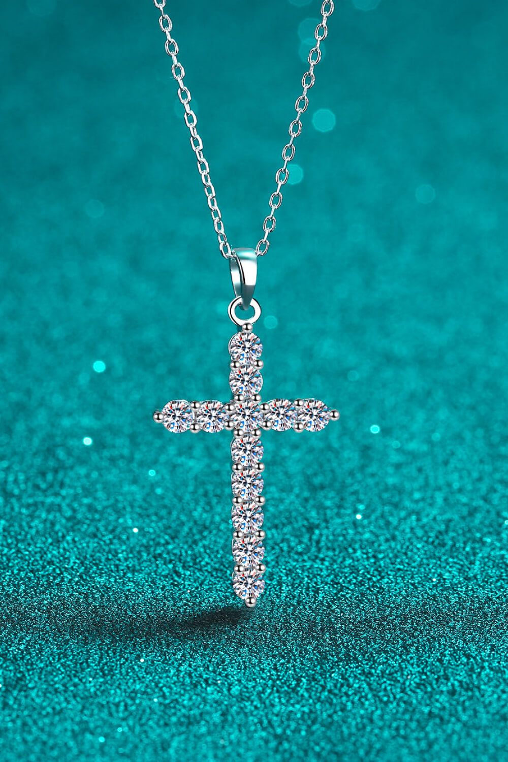 Silver moissanite cross pendant on chain featuring a sparkling stone cross
