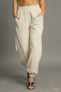 Ecru drawstring jogger pants with front seam detail, elastic waistband and cuffs