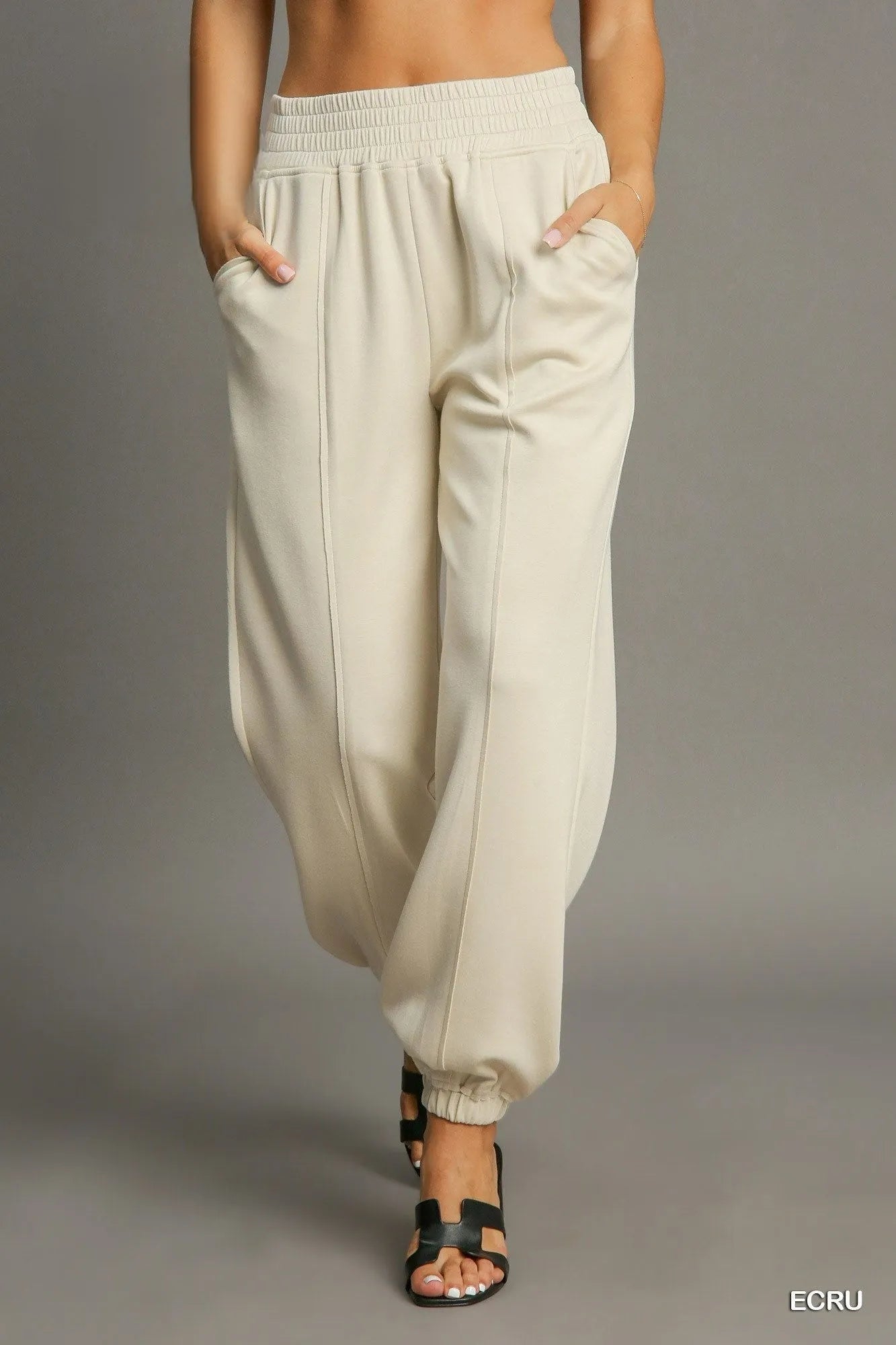 Ecru drawstring jogger pants with front seam detail, elastic waistband and cuffs