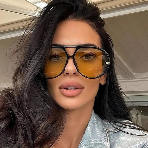 Aviator sunglasses with yellow-tinted lenses and dark frames, metal bridge and arms.