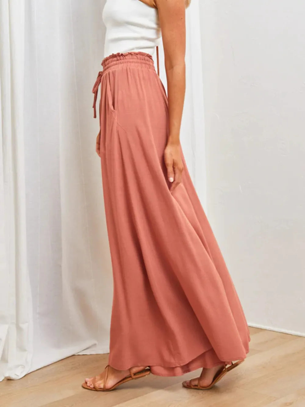 High-waist wide-leg pants in coral with elastic waistband, drawstring ties, and wide hem