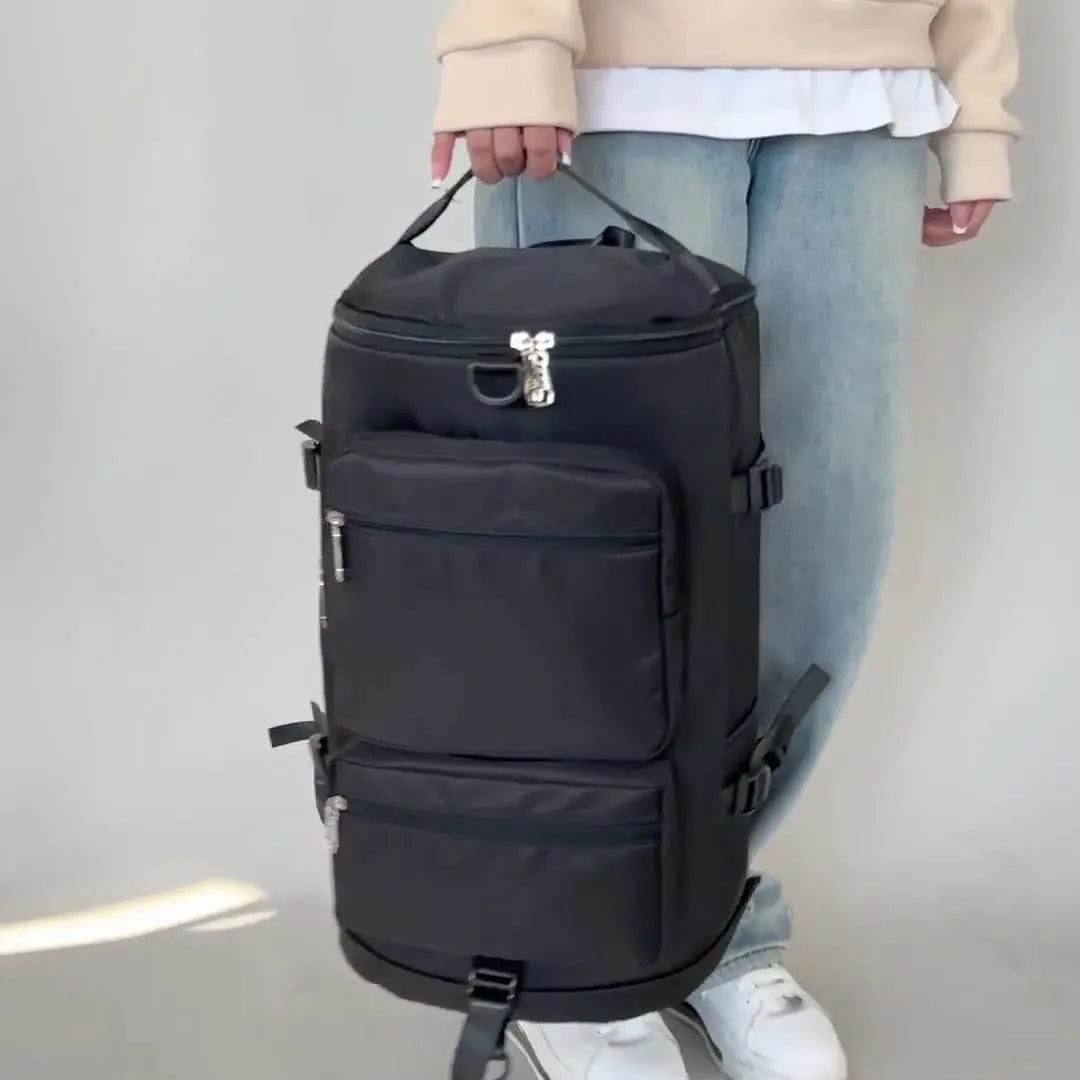 Black large travel backpack with stacked front zip pockets and adjustable side straps.