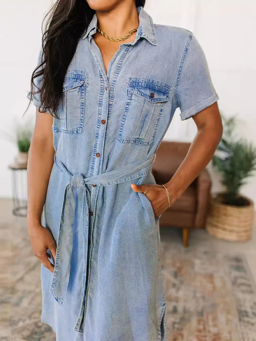 Light blue denim shirt dress with button front, short sleeves, patch pockets, tied waist