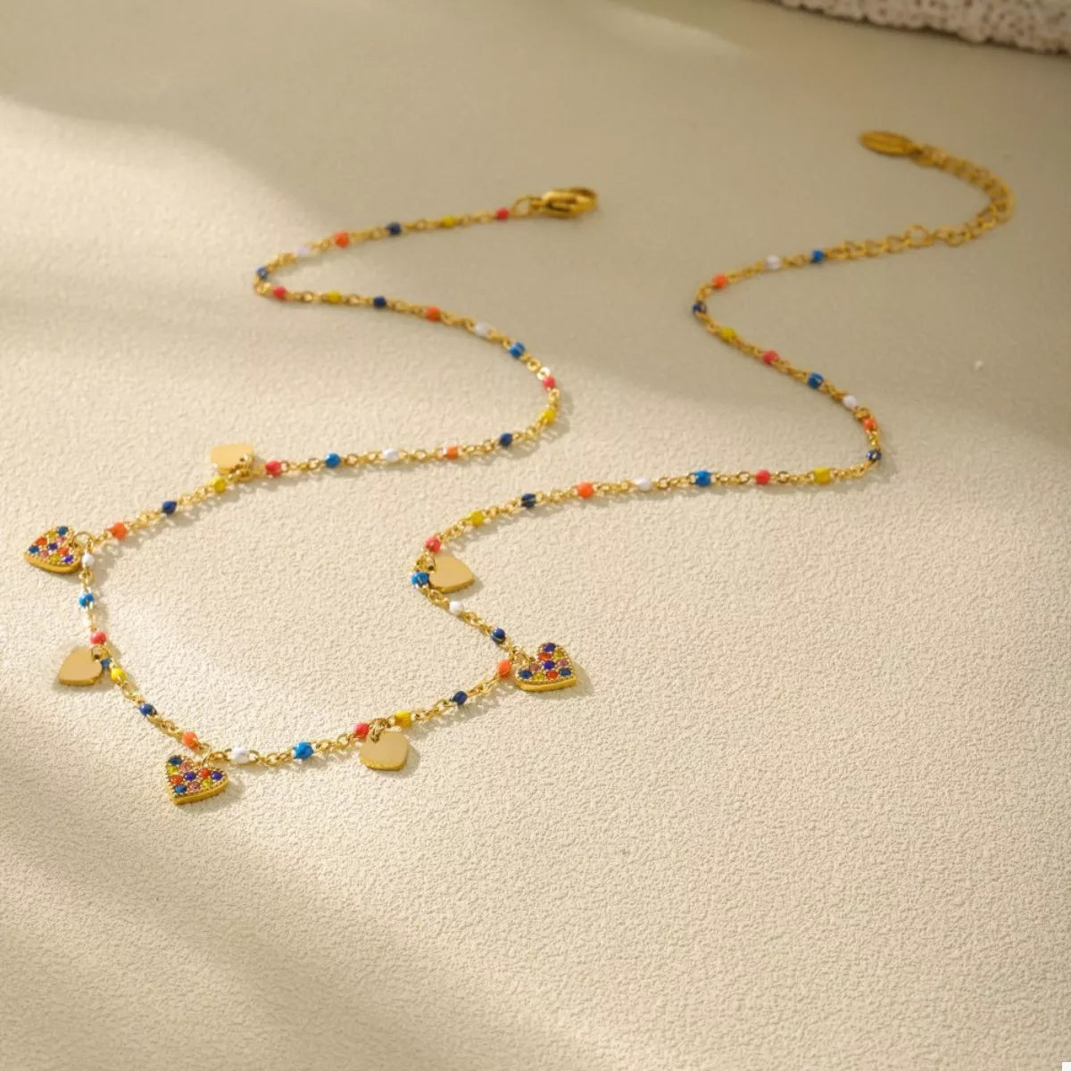 Gold-plated heart charm necklace with colorful beads and small heart pendants