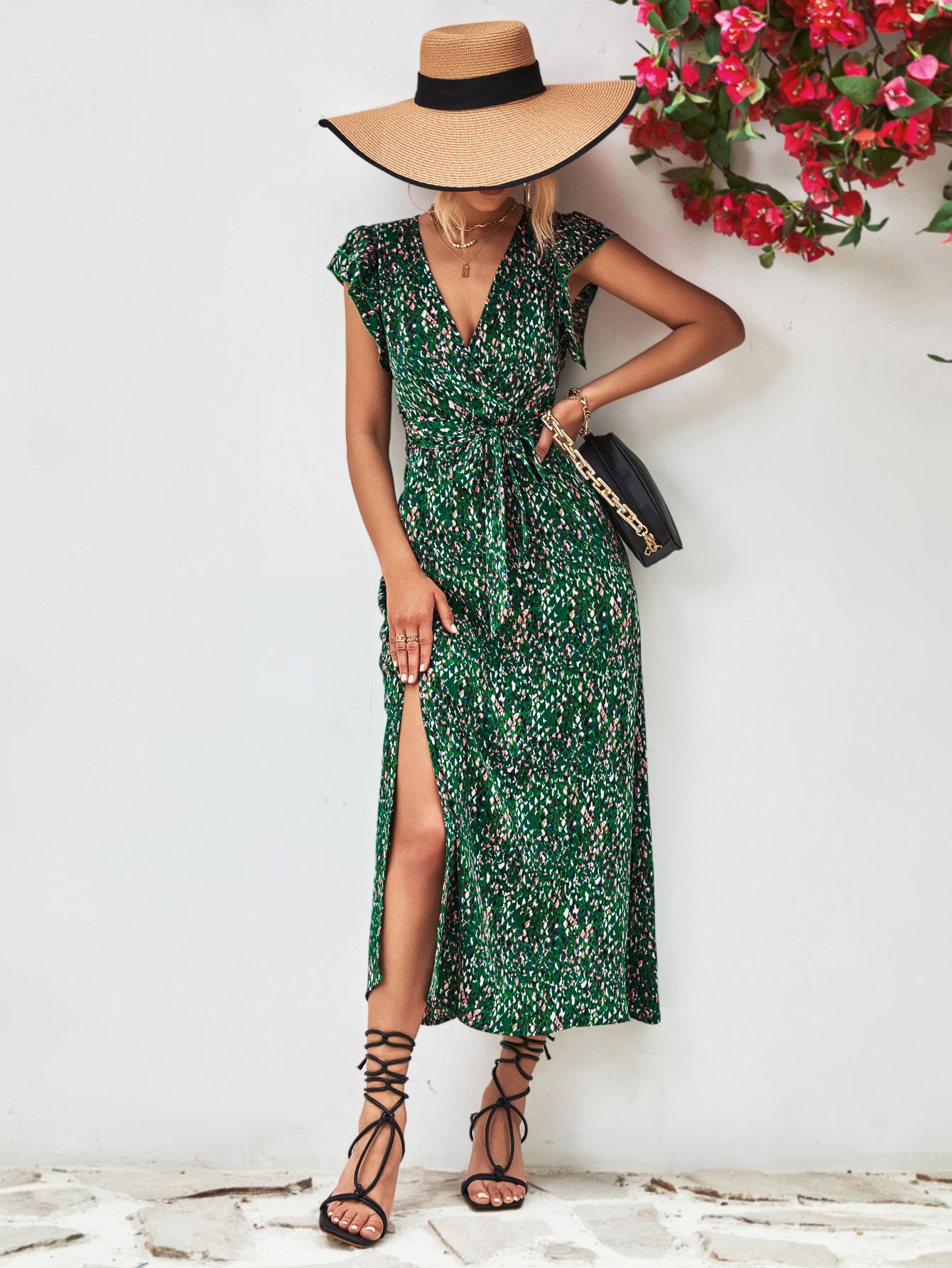 Green printed surplice neck flutter sleeve slit dress with side slit, front three-quarter view.