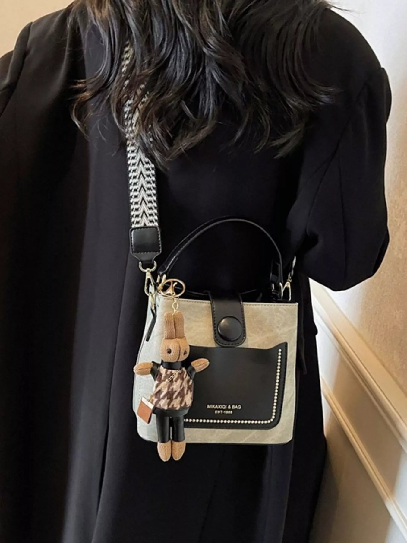 Two-Tone PU Bucket Crossbody Bag in beige/black with black front pocket and chevron strap