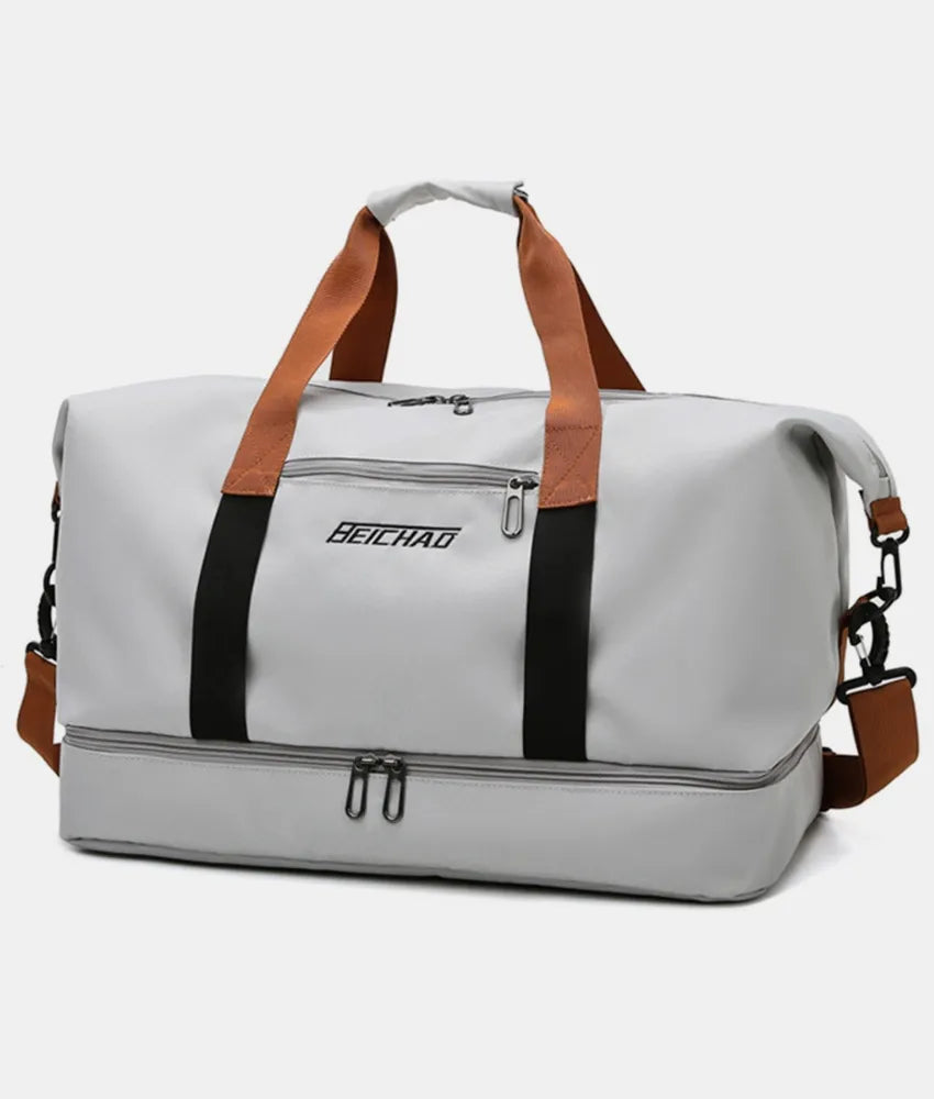 Oversize travel duffle bag in light gray with brown straps and black center stripe