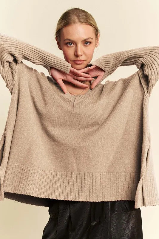 Tan ribbed V-neck sweater with folded neckline and cuffed sleeves