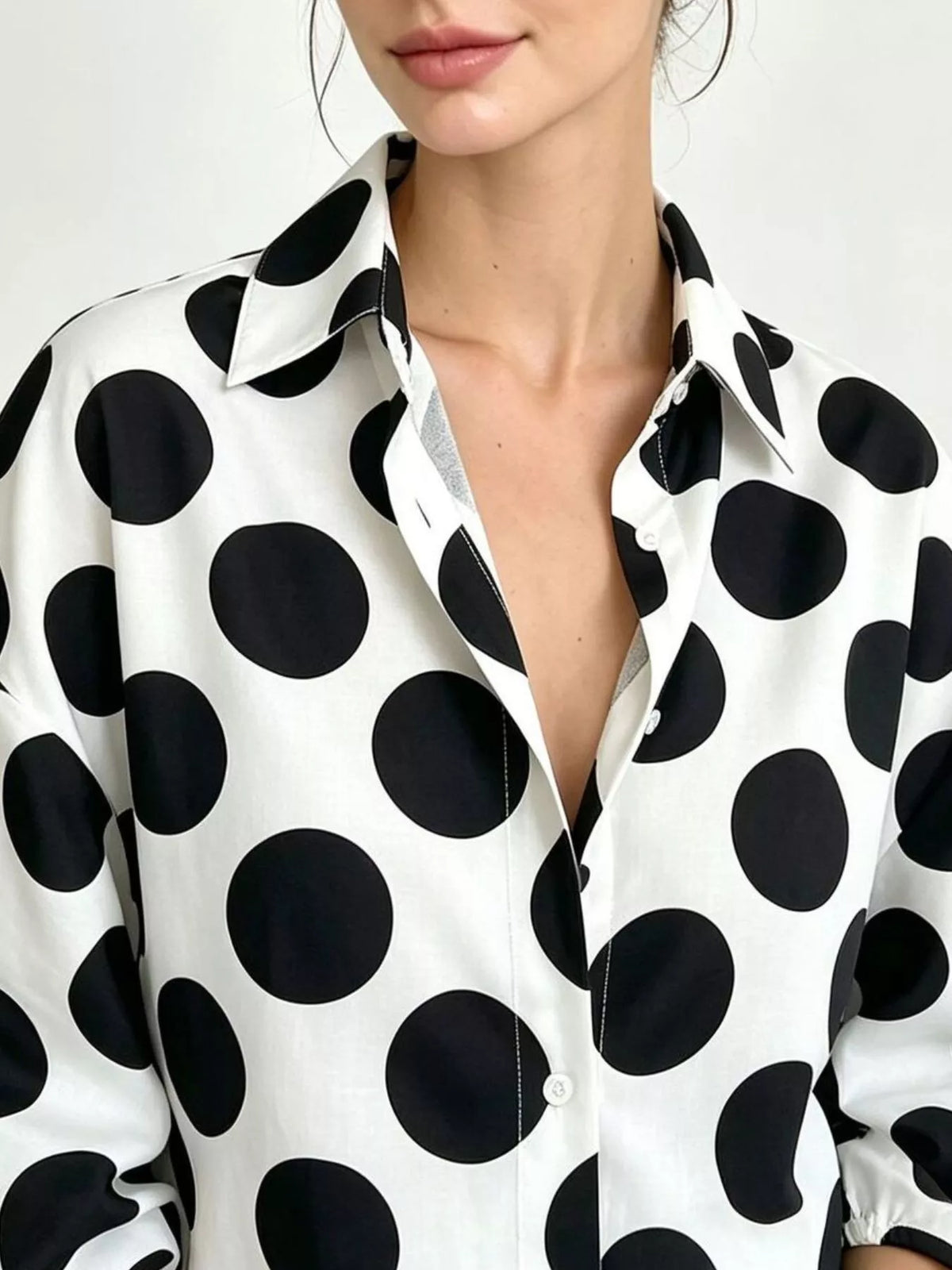 White polka dot button-front shirt with pointed collar and open neckline