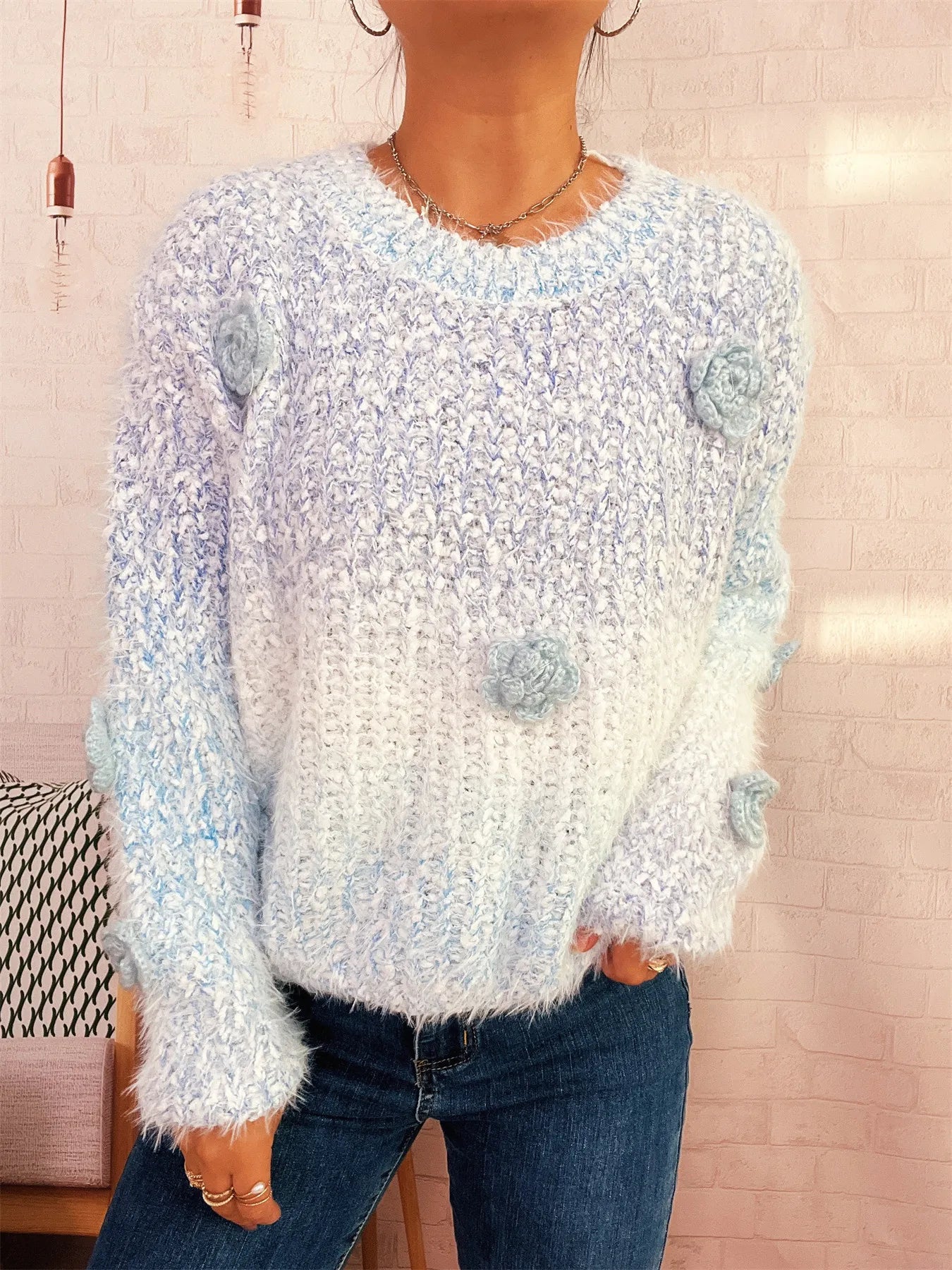 Light blue round-neck sweater with flower appliques, long sleeves, fuzzy knit.