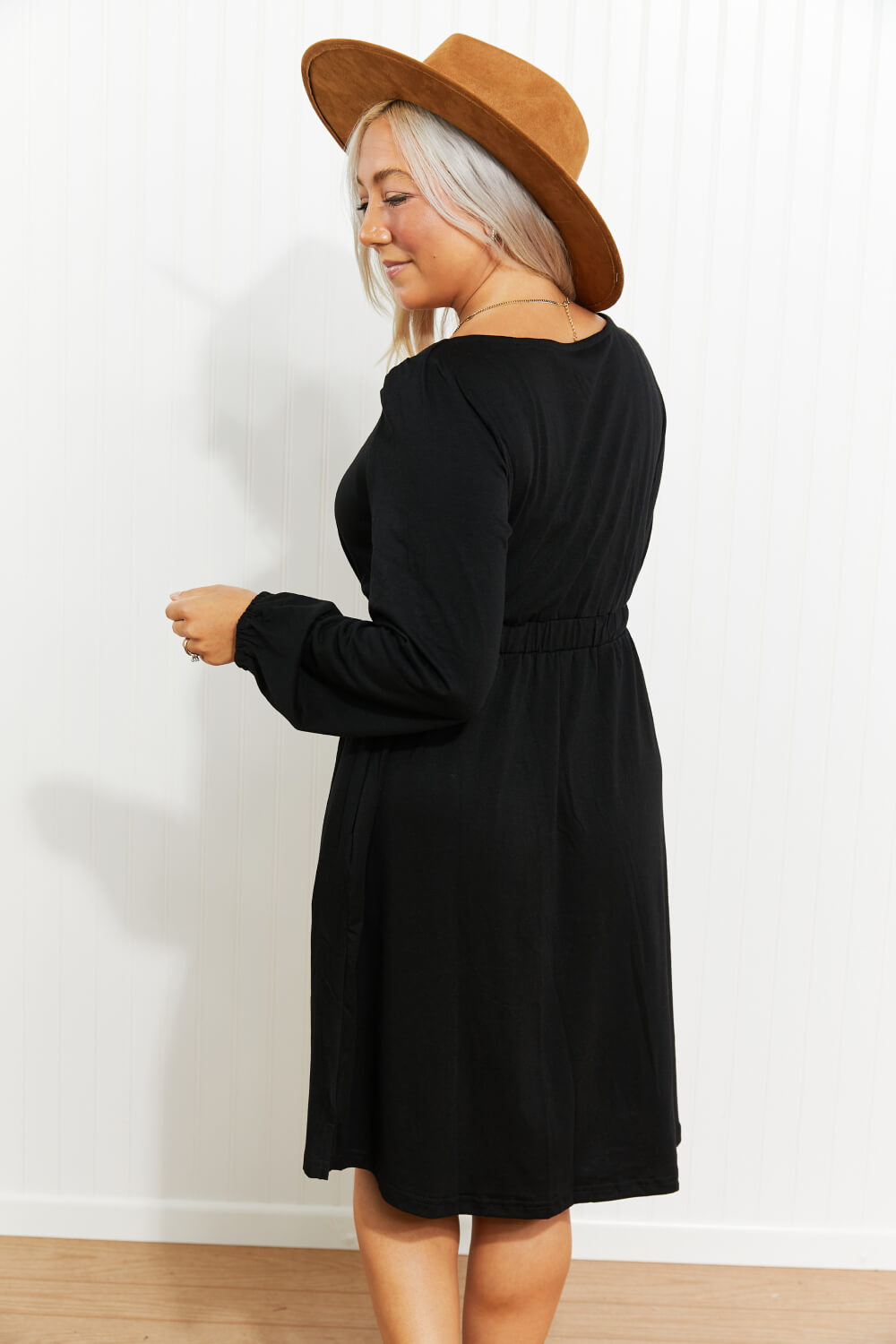 Black long sleeve mini dress back view with gathered empire waist seam