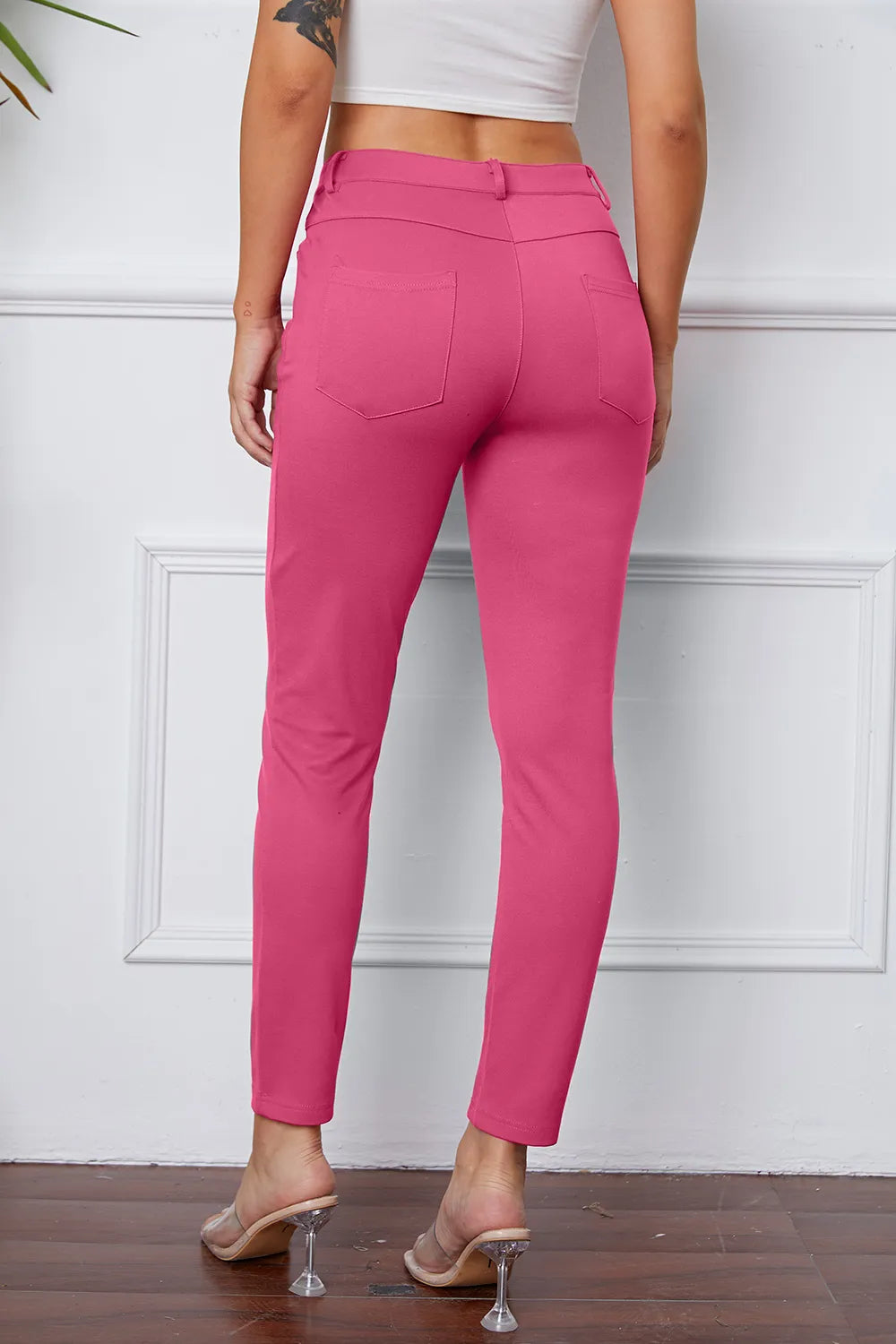 Stretchy pink pants, rear view, with button waistband and slim ankle-length leg
