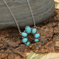 Turquoise oval stone pendant necklace on silver-tone chain, clustered flower design.