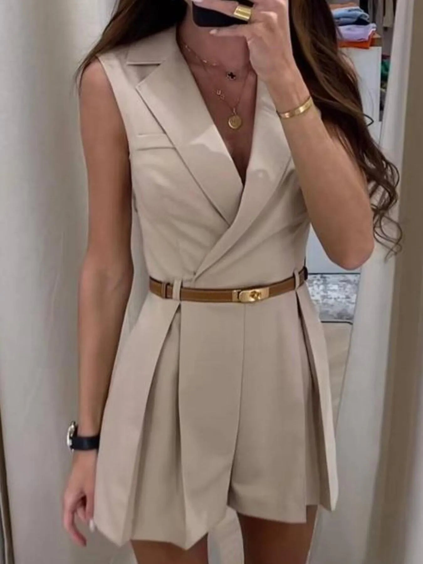 Apricot sleeveless surplice romper with V-neck and gold-buckle belt, pleated shorts