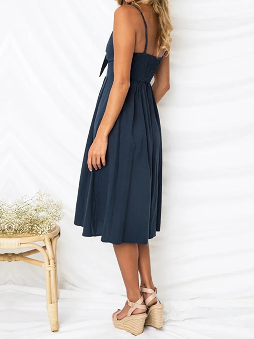 Navy cami dress with narrow straps, back view, button placket, flared mid-length skirt