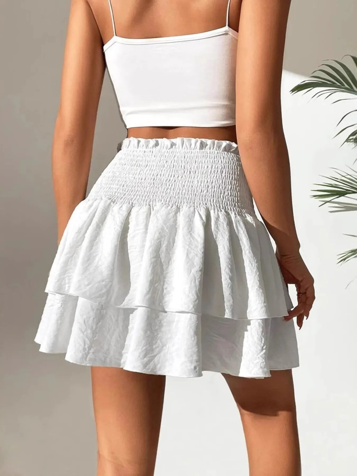 White tiered smocked mini skirt with gathered waistband and ruffled layers