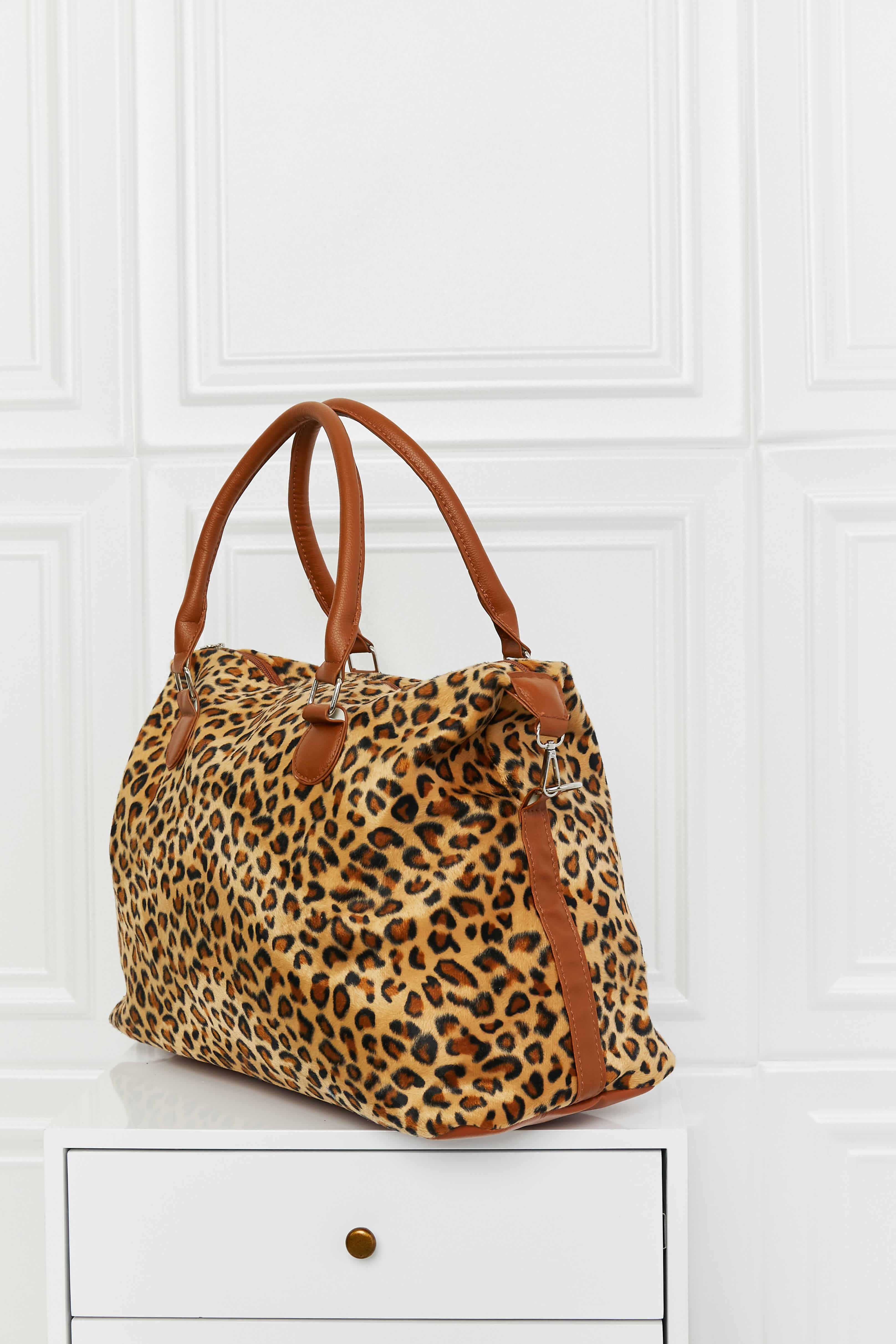 Leopard print weekender bag with tan handles and front toggle detail