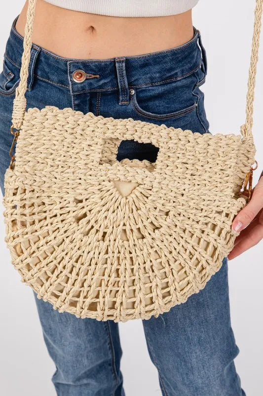 Braided ivory semi-circle tote bag close-up with black cutout pocket and woven texture