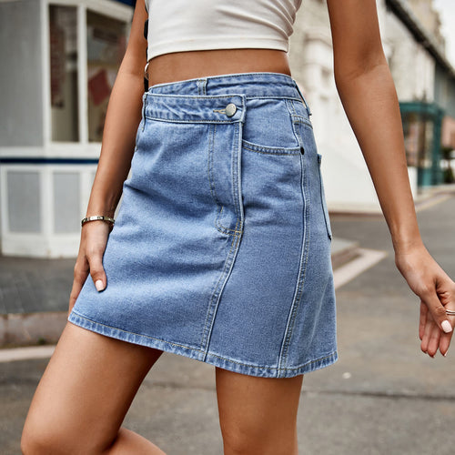 Medium wash denim mini skirt with front button and diagonal asymmetrical hem.