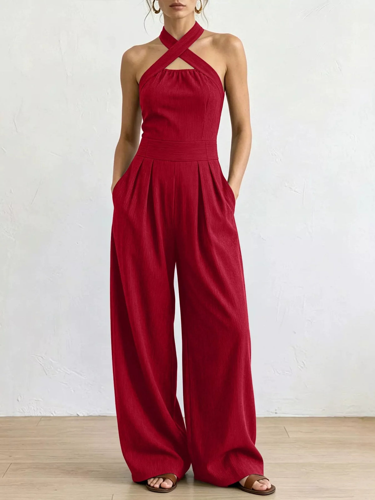 Red halter linen jumpsuit with high waist and flowing wide-leg trousers