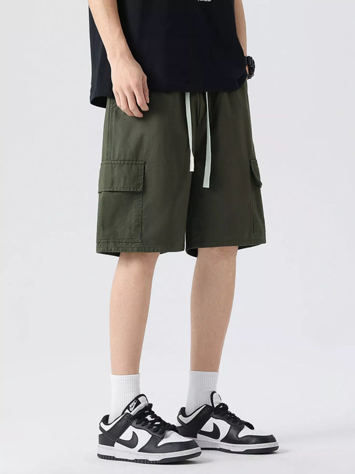 Men's military green cargo shorts with drawstring waist and side patch pocket.
