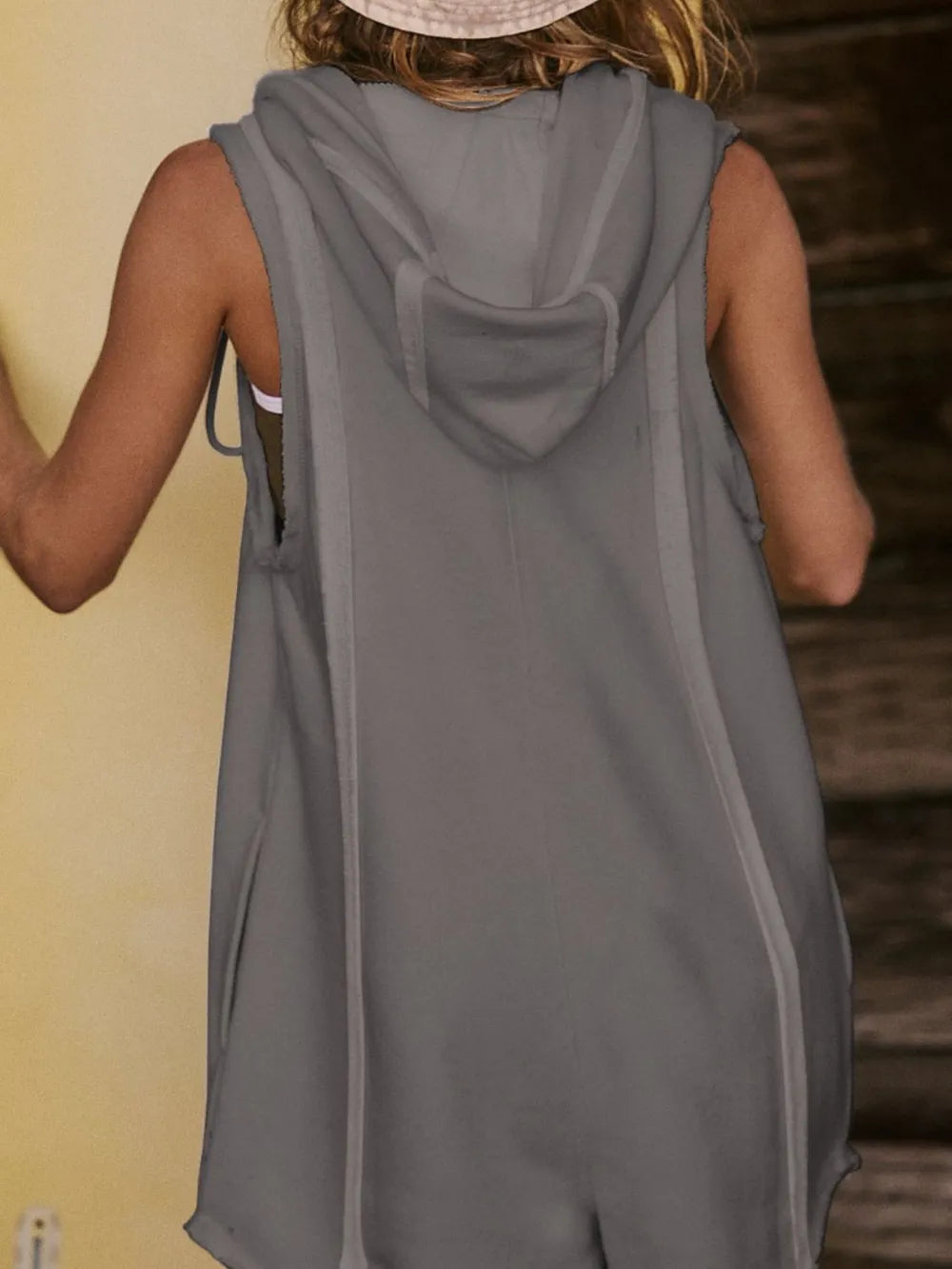 Gray hooded sleeveless romper back view with draped hood and drawstring ties