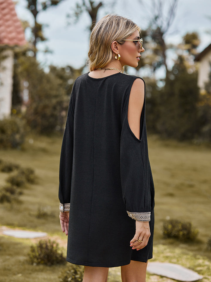 Black V-neck mini dress with cutout sleeves and embroidered trim at cuffs