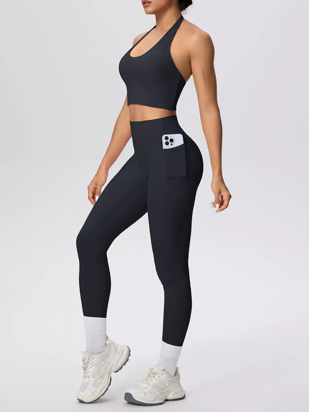 Black halter crop top with high-waist pocket leggings, front view with pocket detail