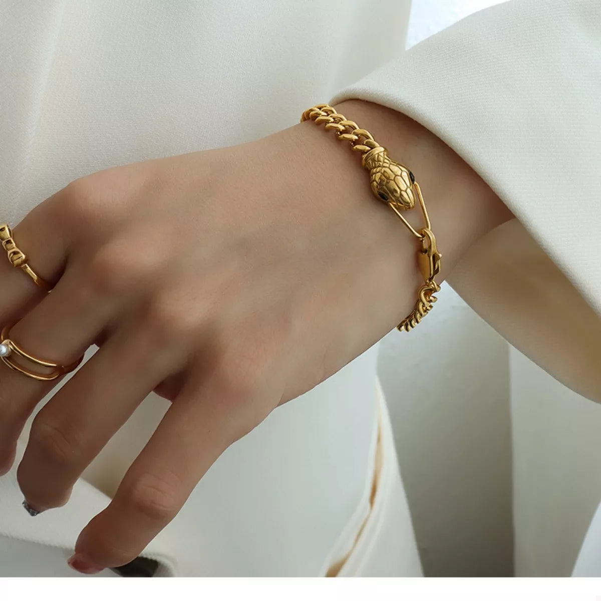 Gold snake-motif chain bracelet with textured clasp on wrist