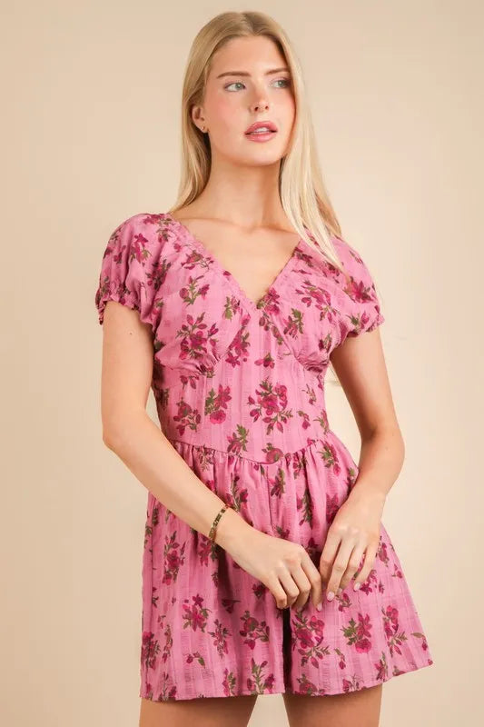Pink floral romper with short puff sleeves, V-neck bodice, and gathered waist