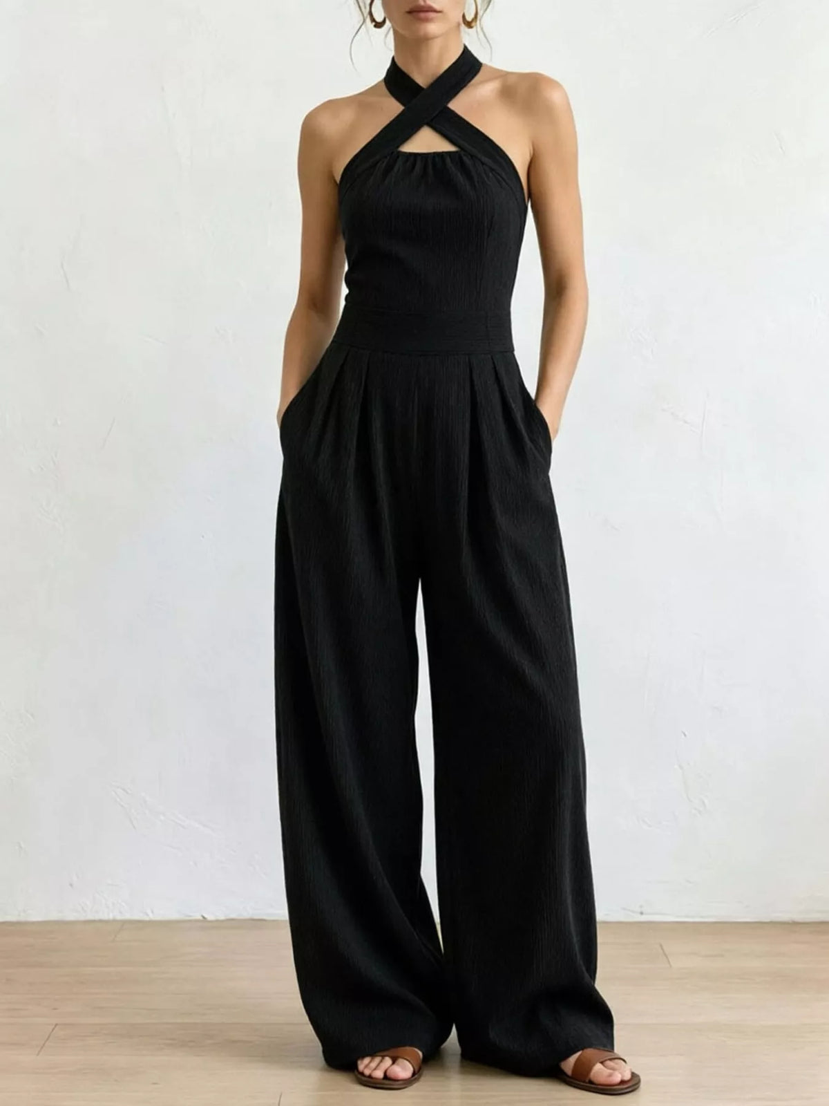 Black linen halter wide-leg jumpsuit with crisscross halter neckline and gathered waist