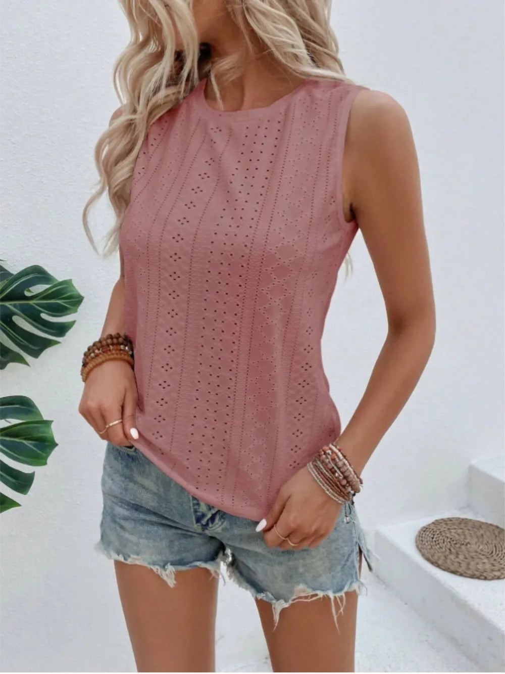 Dusty pink eyelet round neck sleeveless tank in a side view with curved hem