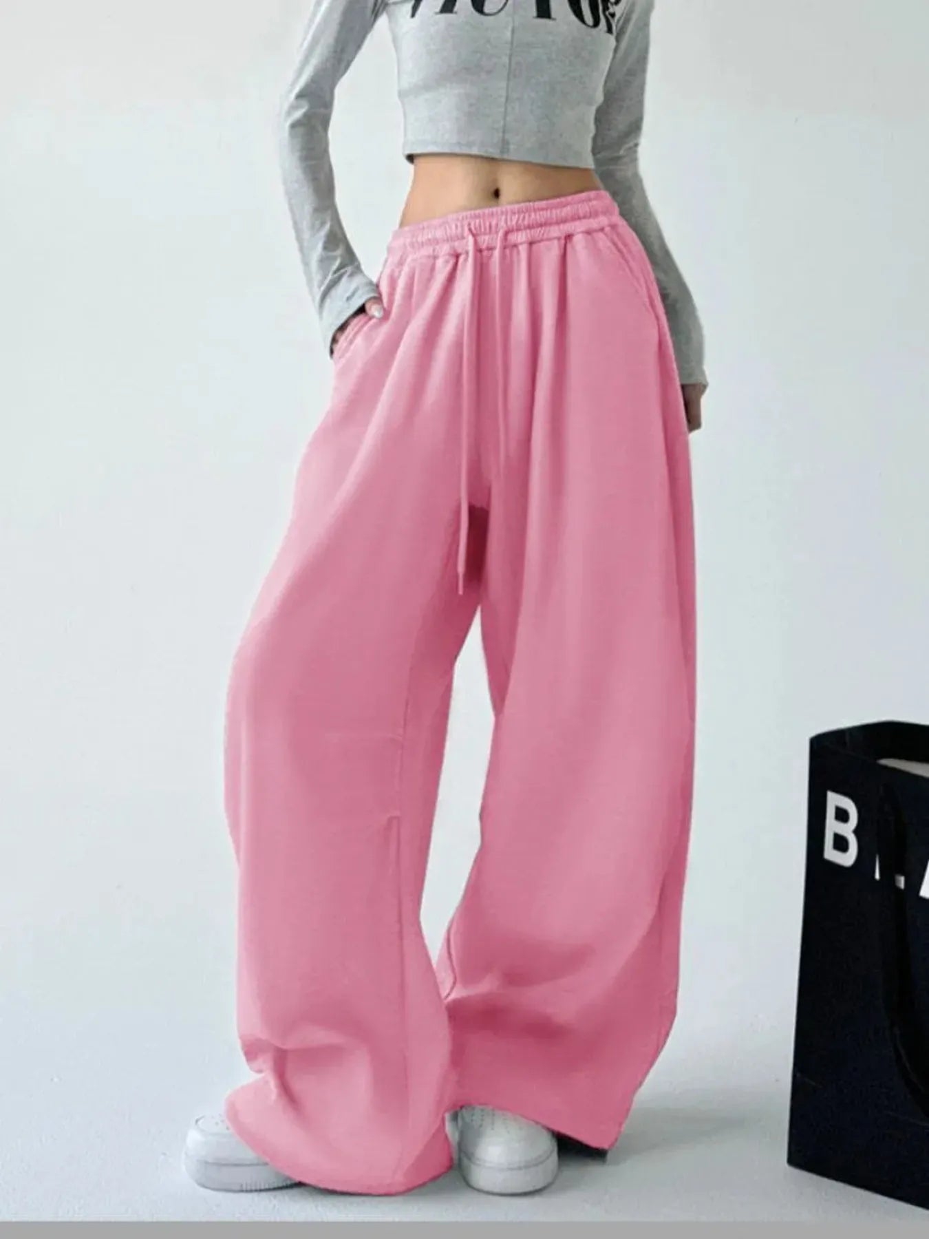 Pink oversized wide-leg drawstring pants with elastic waistband and long loose legs