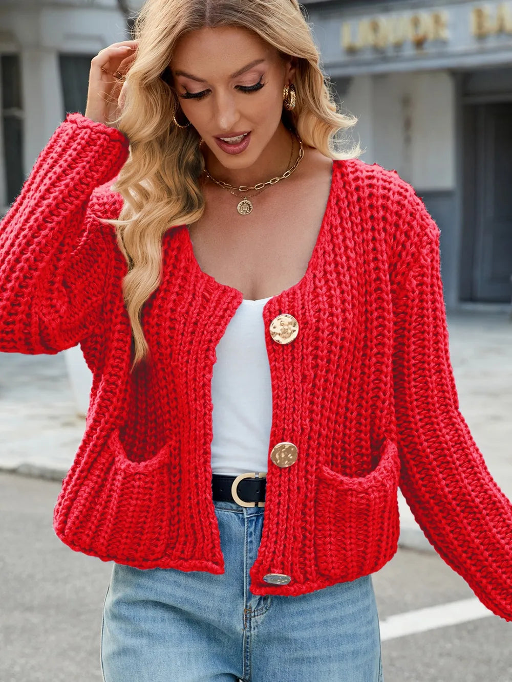 Red knit cardigan with round neckline, button front, and patch pockets