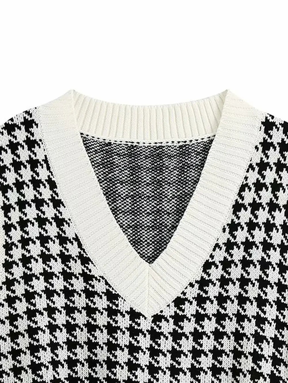 Close view of black and white houndstooth V-neck sweater vest knit with ribbed edging