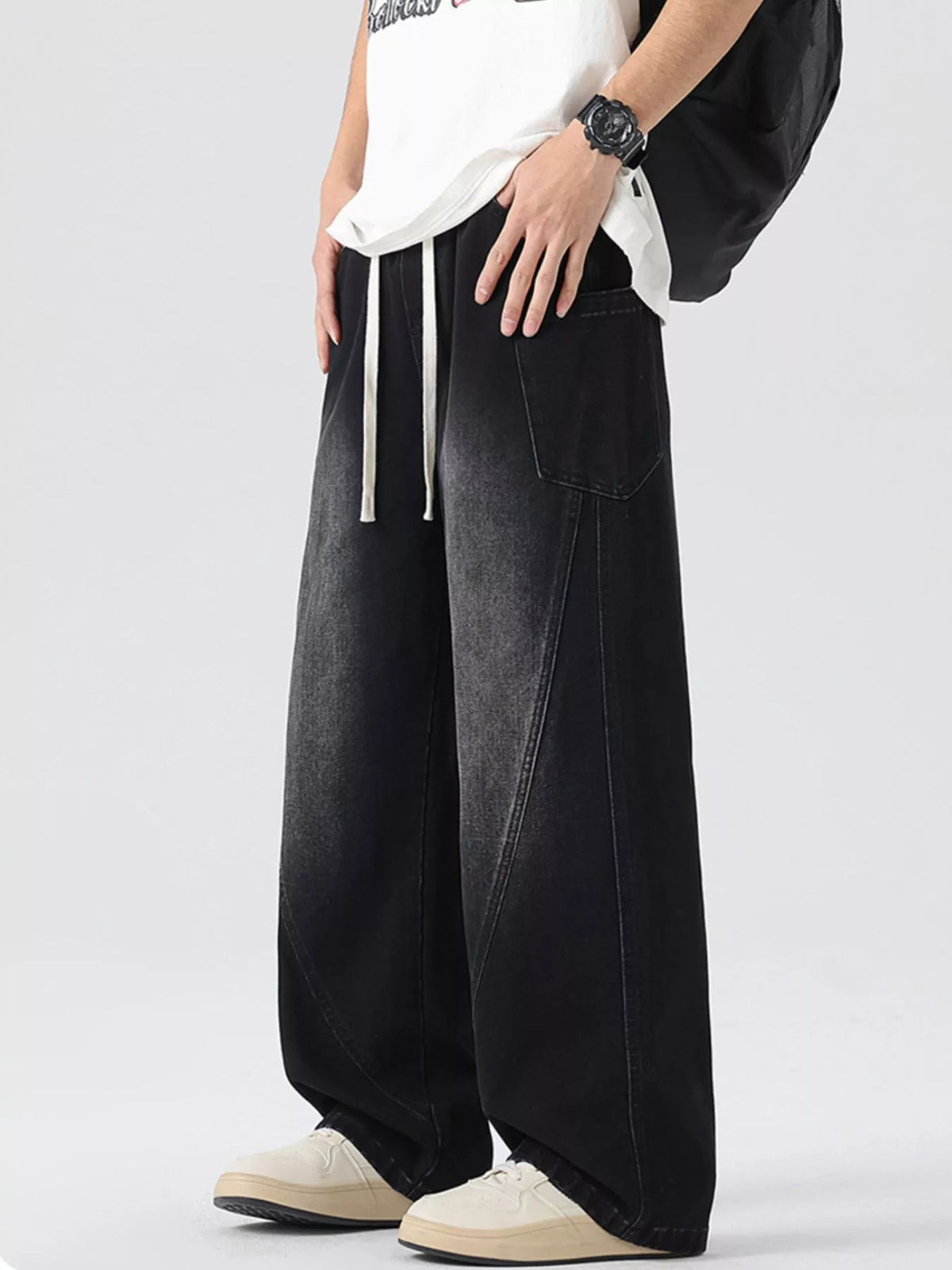 Men's vintage wide-leg jeans in dark denim with drawstring waist, loose oversized legs.