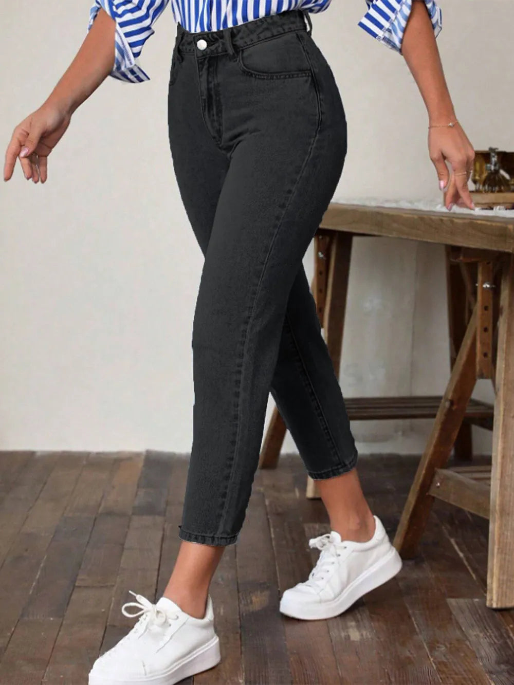 Black high-waist jeans with pockets, ankle-length slim fit, angled side view