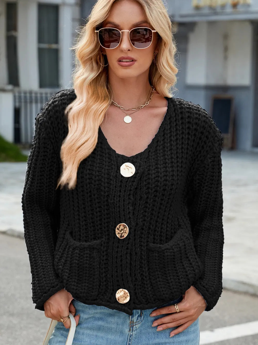 Black knit cardigan with round neckline, button front, and patch pockets